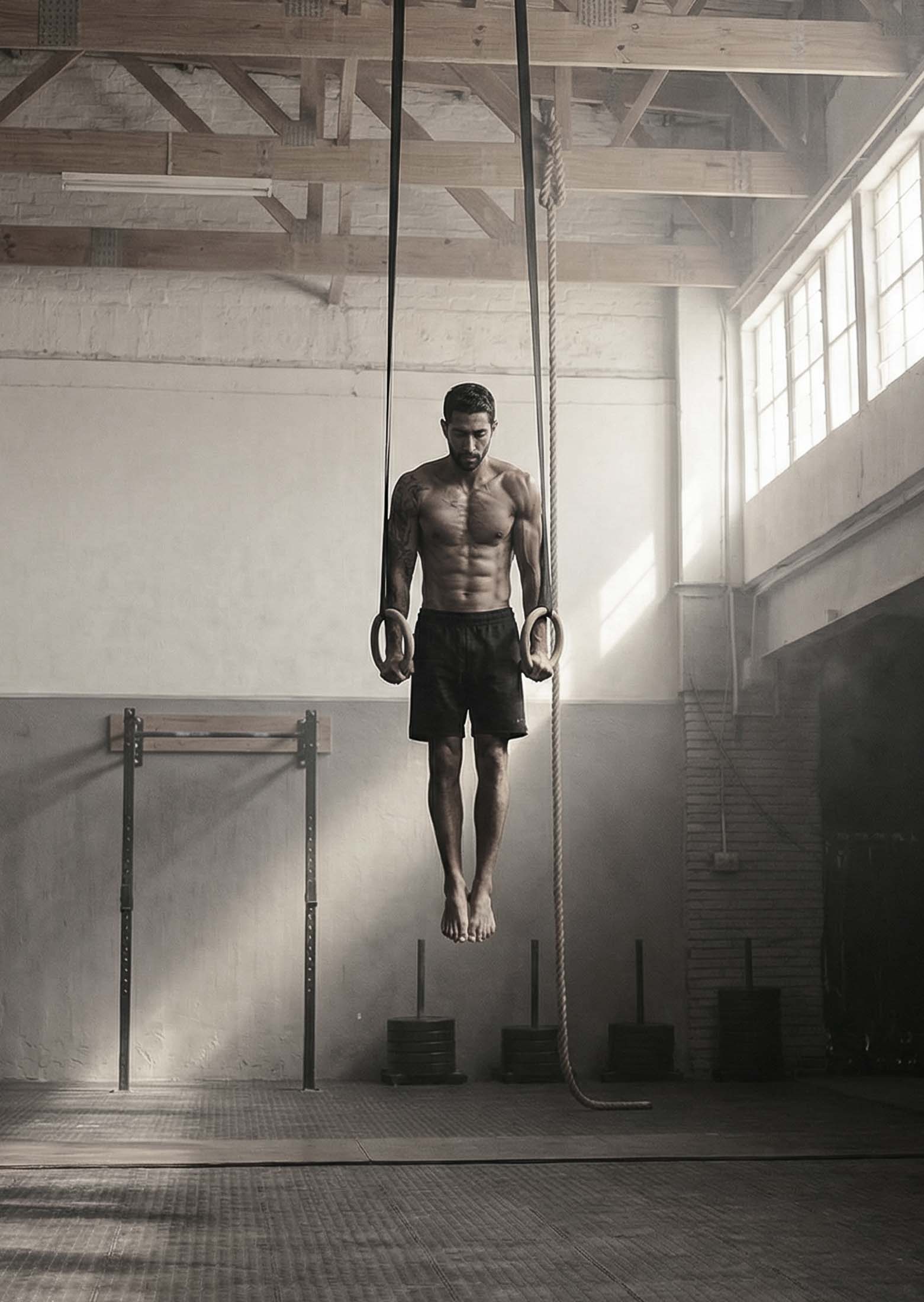 Beginner athlete training with gymnastic rings in a controlled indoor workout